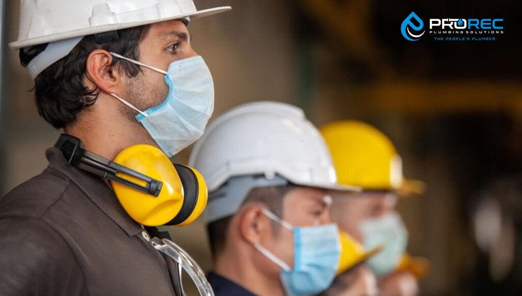Workers wear protective face masks for safety in machine industrial factory - ProRec Plumbing